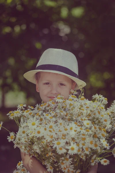 Портрет очаровательный мальчик в шляпе с большим белым букетом ромашки — стоковое фото