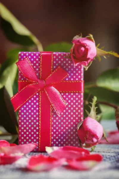 Handmade box with gift  on old pink roses background. — Stok fotoğraf