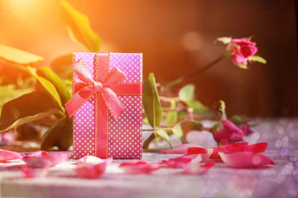 Handmade box with gift  on old pink roses background. — Stok fotoğraf