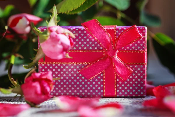 Handmade box with gift  on old pink roses background. — Stok fotoğraf