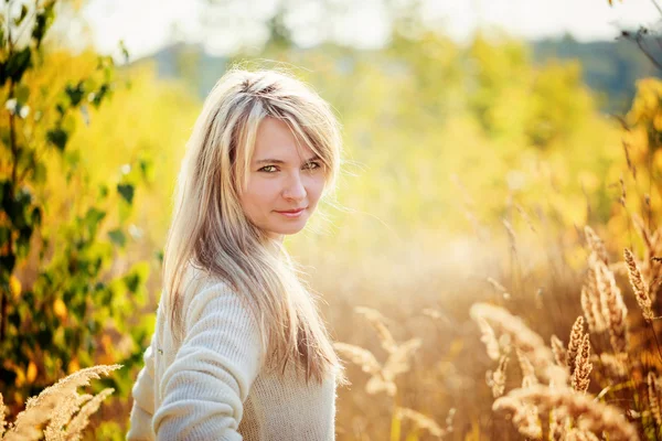 Jong meisje portret genieten van de schoonheid van zonnige herfstdag in hoog gras in een herfst park — Stockfoto