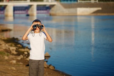 Mutlu çocuk deniz dürbün mavi su arka planı arıyorum. Çocuk doğa üzerinde eğleniyor. Yaz deniz rüya ve hayal.