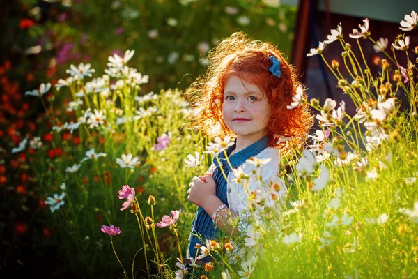 Portret piękne kręcone na czele czerwony dziewczynka w Blossoming garde — Zdjęcie stockowe