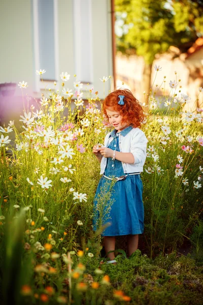 Kıvırcık kafalı güzel kırmızı kız bir cl Blossoming bahçesinde — Stok fotoğraf