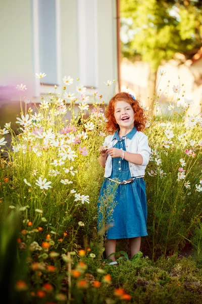 Kıvırcık kafalı güzel kırmızı kız bir cl Blossoming bahçesinde — Stok fotoğraf