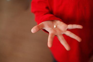 El ile bir süt diş. İlk dişini kaybetti.