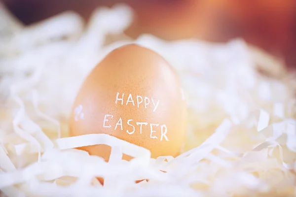 Huevo de Pascua marrón con texto Feliz Pascua. Imagen tonificada —  Fotos de Stock