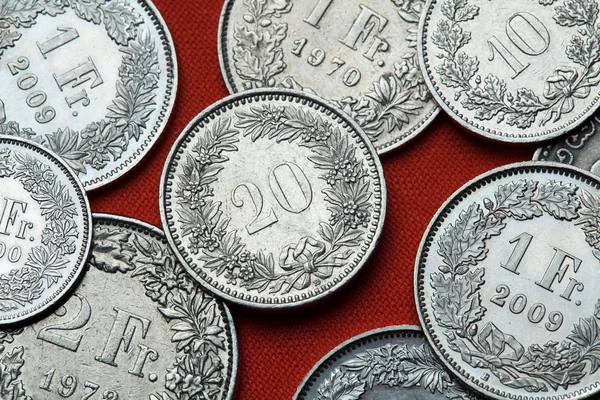 Moedas da Suíça em mesa vermelha — Fotografia de Stock