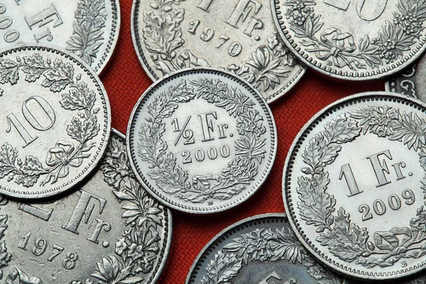 Coins of Switzerland on red table — Stock Photo, Image