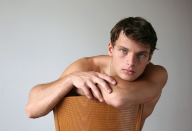 sandalyenin üzerinde seksi bir adam. kopya alanı.