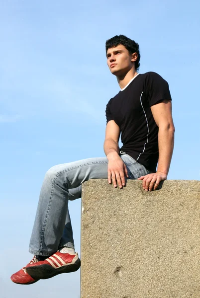 Adolescente sentado nos blocos de pedra — Fotografia de Stock