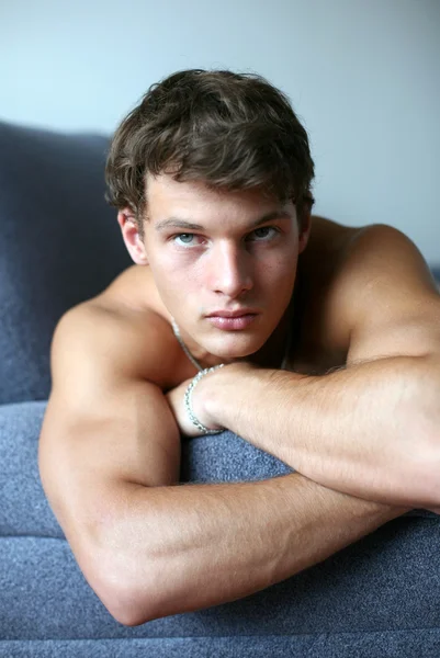 Sexy jovem homem no o sofá — Fotografia de Stock
