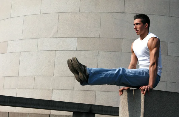 Muscular Gymnast holding his legs ahead — Stock Photo, Image