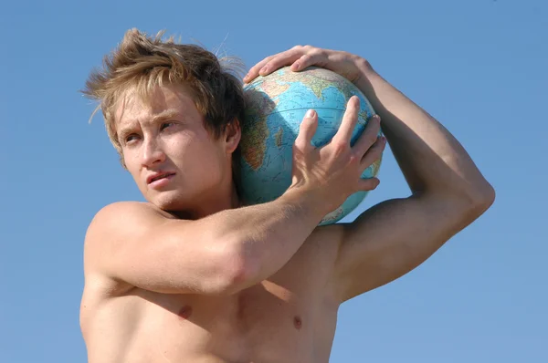 Młody człowiek mięśni z globusem — Zdjęcie stockowe