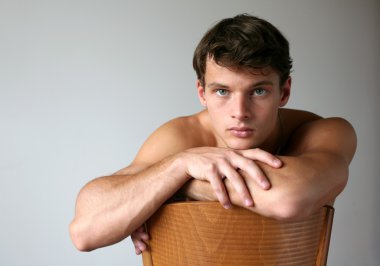 sandalyenin üzerinde seksi adam