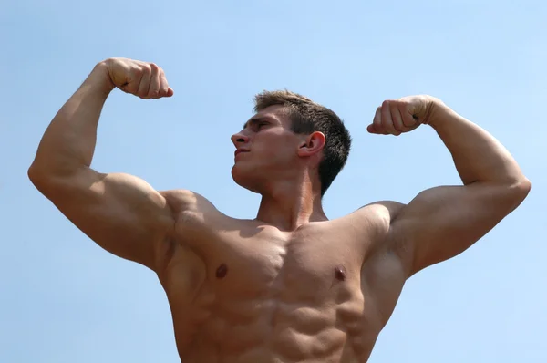 Muskularny mężczyzna pokazano jego biceps — Zdjęcie stockowe