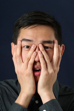 Asya adam parmaklarının arasından bakan