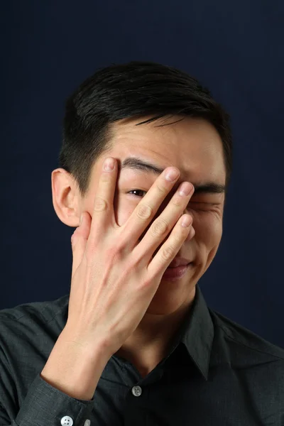 Asiatico uomo guardando attraverso la sua dita — Foto Stock