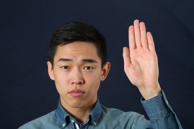 Dur işaretini veren Asyalı adam