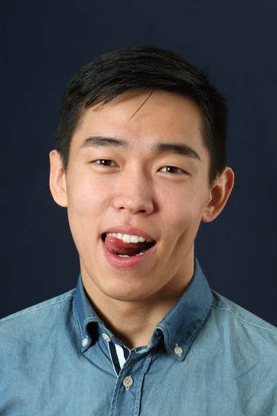 Azjatycki człowiek wyświetlone język — Zdjęcie stockowe