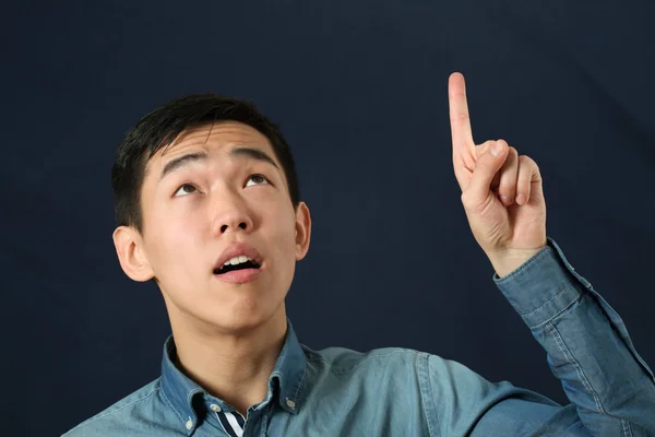 アジア人の男性が彼の人差し指を指しています。 — ストック写真