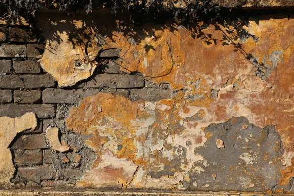 Parede de tijolo velho com gesso rachado — Fotografia de Stock