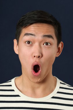 Şaşırmış gibi genç Asyalı adam yukarı doğru bakan