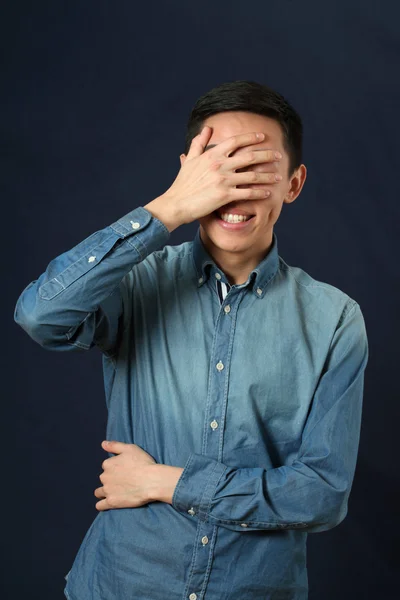 Azjatycki człowiek ukrywszy twarz przez dłoń — Zdjęcie stockowe