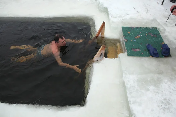 NOVOURALSK, RUSSIA - FEBRUARY 23, 2011: Traditional Russian winter swimming in the Verkh-Neyvinsky Pond near Novouralsk in the Urals Mountains, Russia.