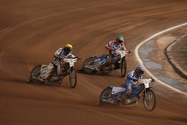 Гонщики на спидвее соревнуются на треке
