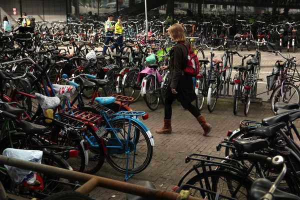 Femme marche à travers la station de stationnement de vélos — Photo