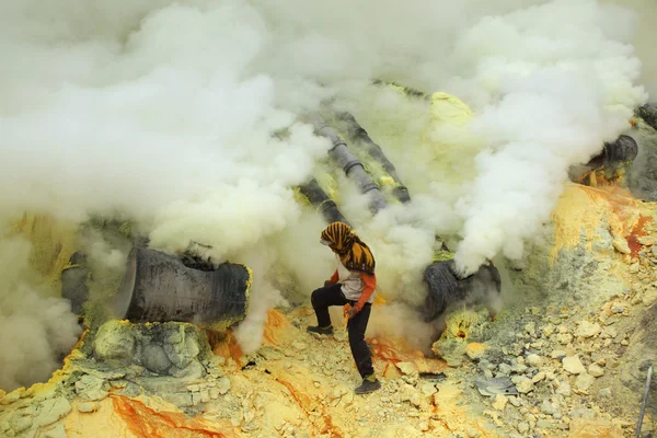 Miner collects sulphur in the fumes — Stock Photo, Image