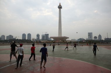 Children play football in Jakarta clipart