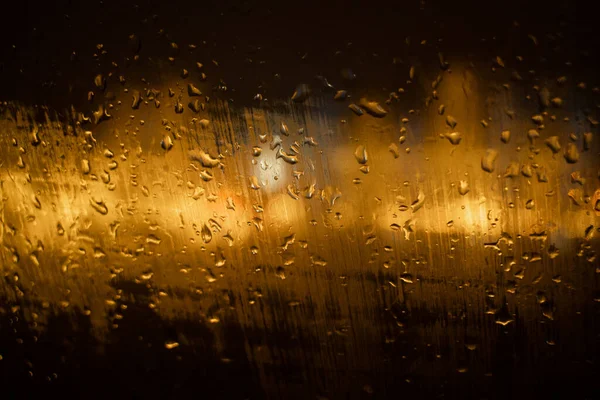 View of the night city through the wet car window with drops — Stock Photo, Image