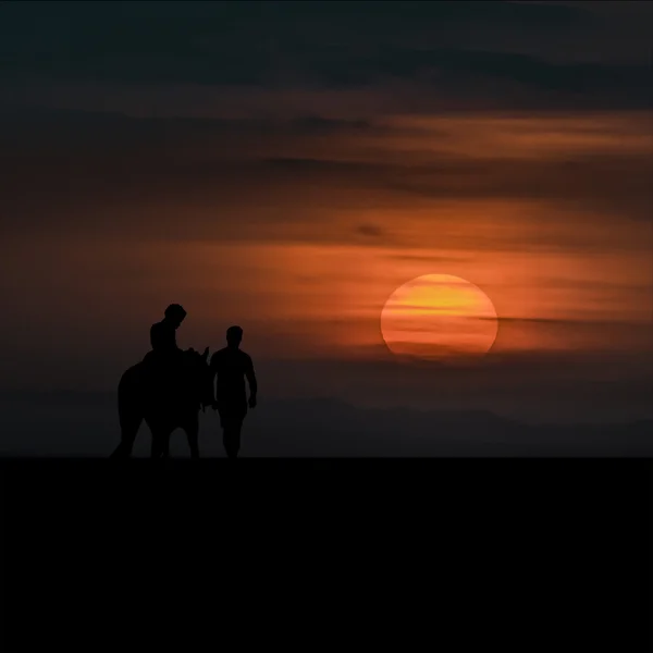 日没で大人の男と馬に乗る子 — ストック写真