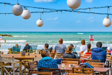 TEL AVIV, ISRAEL, ARALIK - 2019 - İnsanlar rıhtım kenarındaki barda güneşli bir günün tadını çıkarıyorlar, tel aviv, İsrail