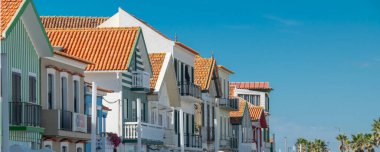 Aveiro, Portugal: August 15 2023: Perspective view of traditional striped houses in Costa Nova, Aveiro,  Portugal, symbol of local identity and colorful architecture
