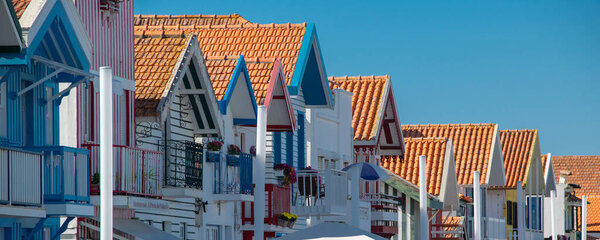 Aveiro, Portugal: August 15 2023: Perspective view of traditional striped houses in Costa Nova, Aveiro,  Portugal, symbol of local identity and colorful architecture