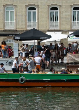 Aveiro, Portekiz: 15 Ağustos 2023: Portekiz 'in Aveiro kentindeki ünlü kanalda park etmiş turistlerle dolu geleneksel moliceiro teknesi