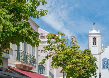 Aviero, Portekiz: 15 Ağustos 2023: Aveiro 'da turist ve kafe teraslarının önünde parlak yaz gökyüzünün altında beyaz bir kilisenin önü.