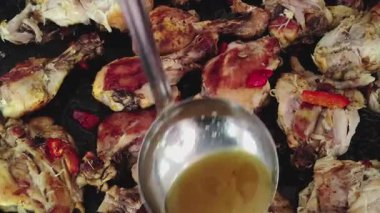 Yakın çekim, yüksek açılı bir görüntü. Bir insanın sosu bir tavuğa dökerkenki görüntüsü.. 