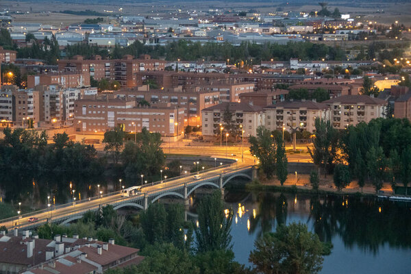 Aerial night view of salamanca city from salamanca cathedral viewpoint with tomes river and modern buildings at background