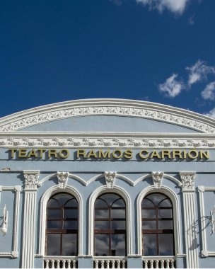Zamora İspanya 'daki Teatro Ramos Carrion' un alçak açılı ön görüntüsü. Mavi modernist bina, süslenmiş beyaz süslemeleri ve geniş pencereleriyle derin mavi gökyüzüne karşı duruyor.