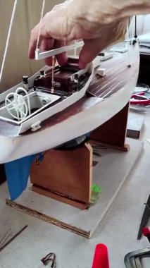 Tahta bir yelkenlinin detaylarını gösteren bir adamın dikey videosu.