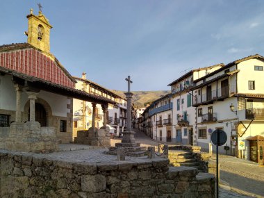 Mavi gökyüzünün altında çan kulesi boyunca uzanan küçük bir şapelin alçak açılı görüntüsü dinginlik, candelario, İspanya