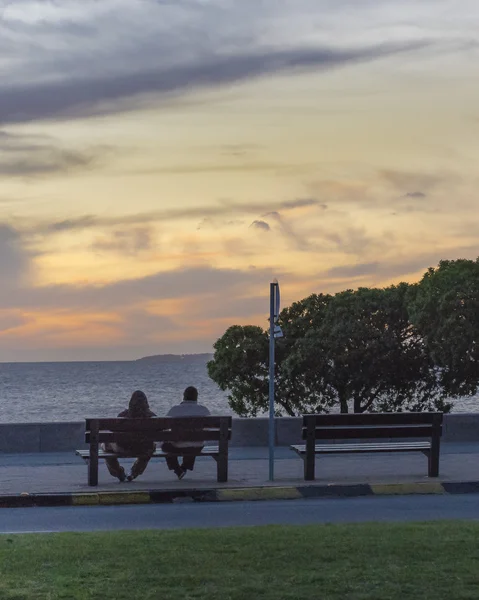 Pareja disfrutando al atardecer en el paseo marítimo de Montevideo — Foto de Stock