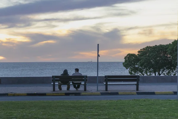 Couple profitant de la scène du coucher du soleil à Boardwalk à Montevideo — Photo