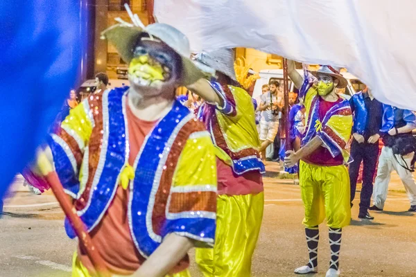 Kostümierte Männer mit Fahne marschieren beim Karnevalsumzug von Uruguay — Stockfoto