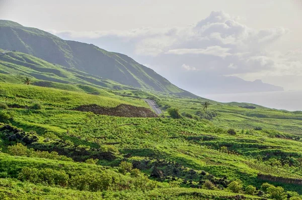 主要公路穿越绿色崎岖的山区 离开佛得角福古岛上的圣若尔热镇 — 图库照片