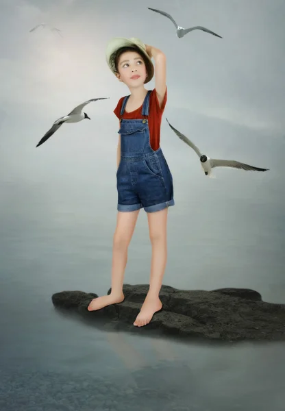 Маленькая девочка и чайки — стоковое фото